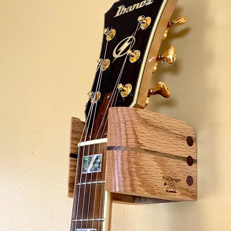 Close Up image of Audinni Guitar Wall Mount Cuff holding guitar