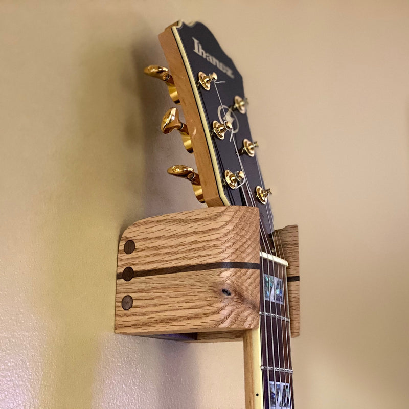 Side view of Audinni Guitar Wall Mount Cuff holding guitar
